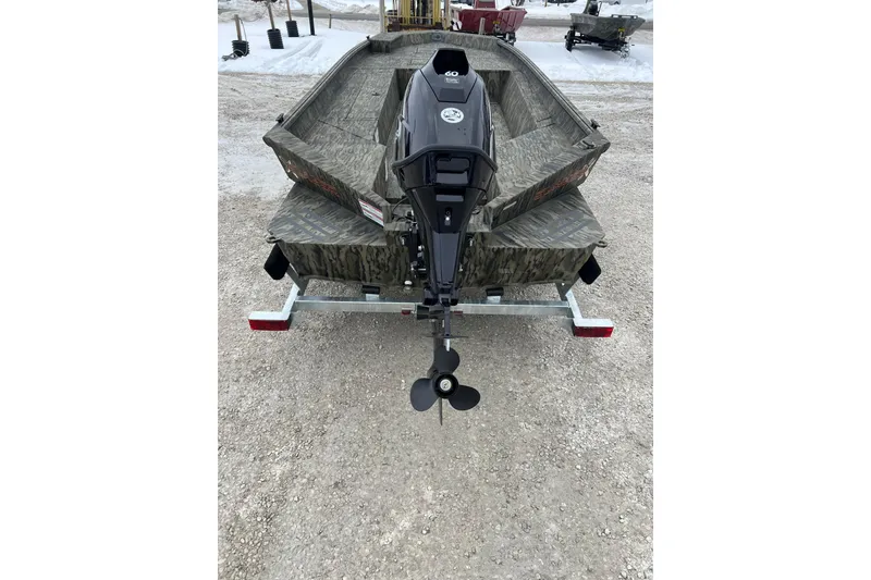 Slide: The Image of 2026 SeaArk 1960 Slayer X boat on trailer, rear view, camo design, snowy background. - 5