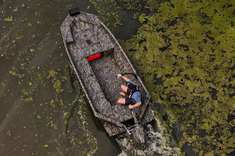 Slide: The Image of Manufacturer Provided Image: Aerial view of 2026 SeaArk 1960 Slayer Pro boat navigating through algae-covered water. - 8