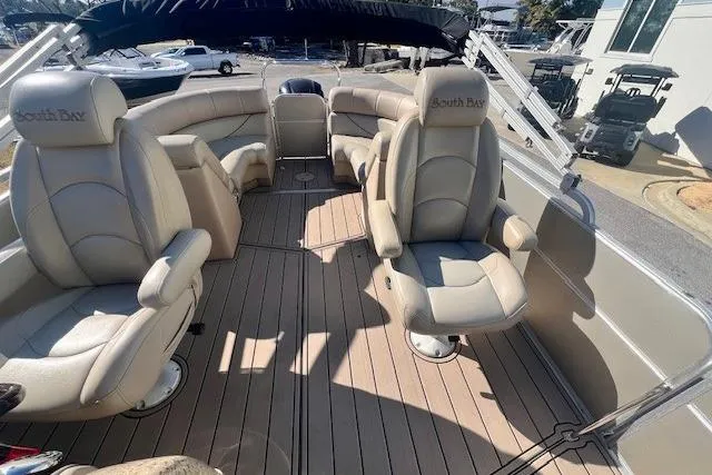 Slide: The Image of 2013 South Bay 722RS pontoon boat interior with beige seating and spacious deck. - 10