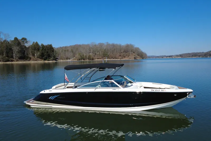 The Image of 2012 Cobalt A28 boat on a serene lake with clear blue skies. - 0