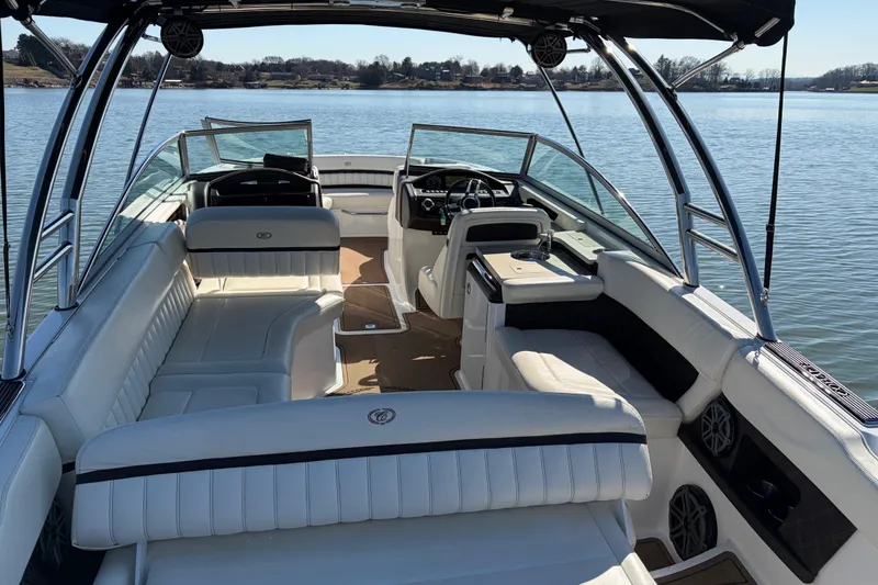 Slide: The Image of 2012 Cobalt A28 boat interior with white seating, on a calm lake. - 10