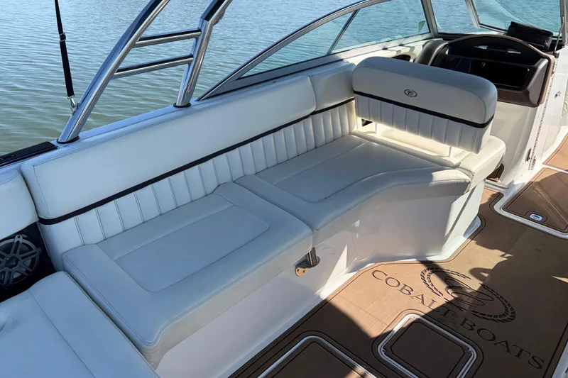 Slide: The Image of 2012 Cobalt A28 boat interior with white seating and wooden flooring. - 11