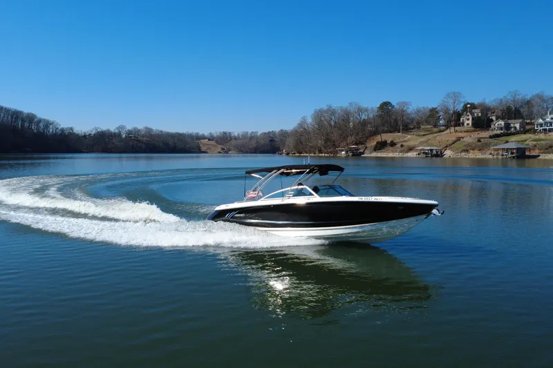 Slide: The Image of 2012 Cobalt A28 boat cruising on a serene lake under a clear blue sky. - 8
