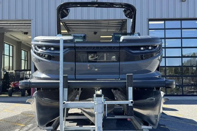 Slide: The Image of 2026 Godfrey Sanpan 2700 ULW pontoon boat on a trailer outside a modern building. - 14