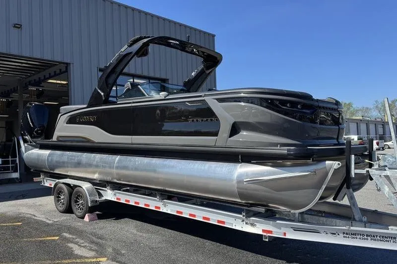 Slide: The Image of 2026 Godfrey Sanpan 2700 ULW pontoon boat on trailer outside a warehouse. - 7