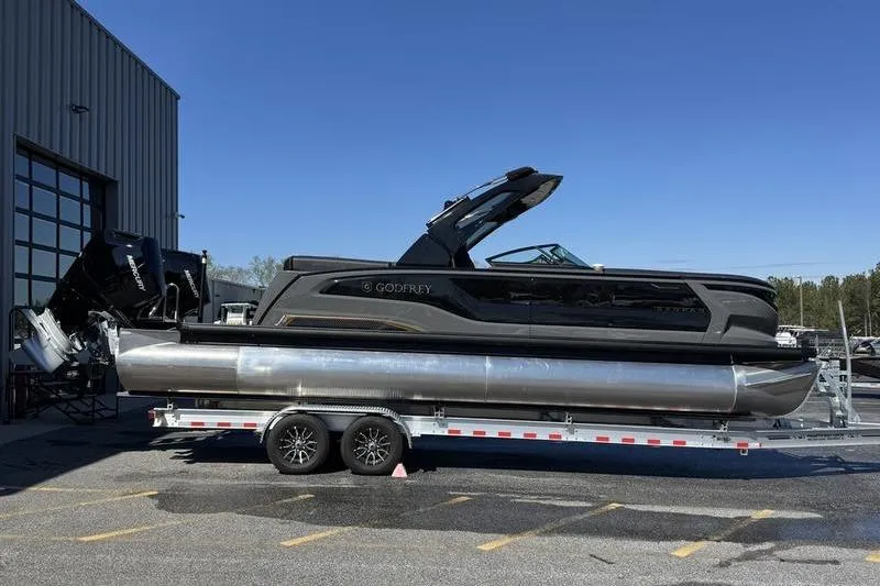 Slide: The Image of 2026 Godfrey Sanpan 2700 ULW pontoon boat on trailer, parked outdoors. - 9