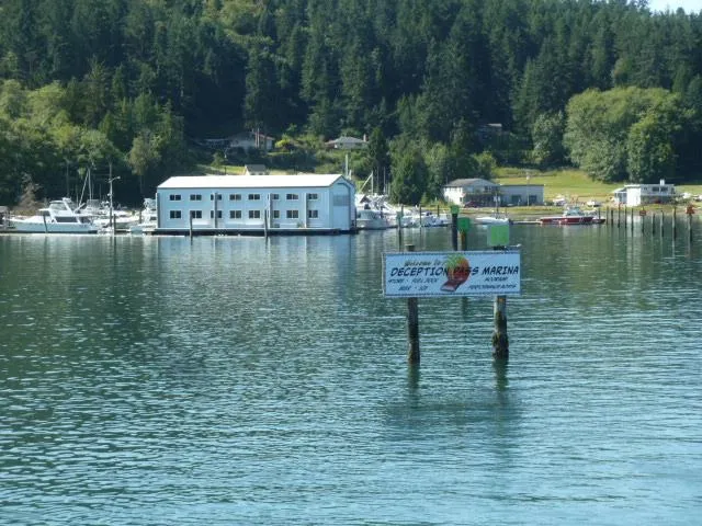 Slide: The Image of 2015 boathouse near marina and forested background. - 2