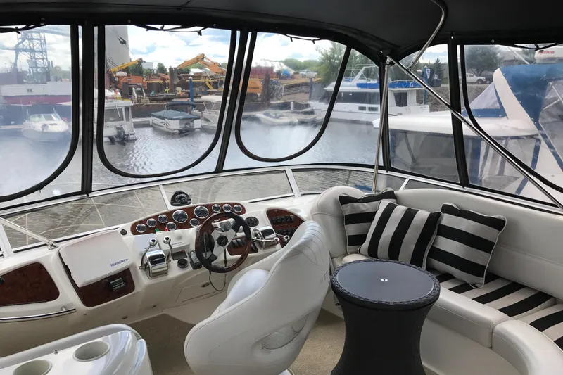 Slide: The Image of 2006 Meridian 408 Motoryacht interior with helm, striped cushions, and marina view. - 10