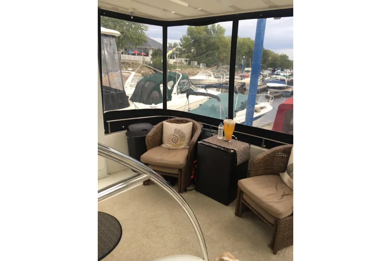 Slide: The Image of 2006 Meridian 408 Motoryacht interior with wicker chairs, table, and marina view. - 12