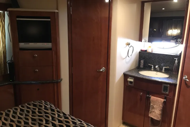 Slide: The Image of 2006 Meridian 408 Motoryacht interior with TV, wooden cabinetry, and bathroom sink. - 21