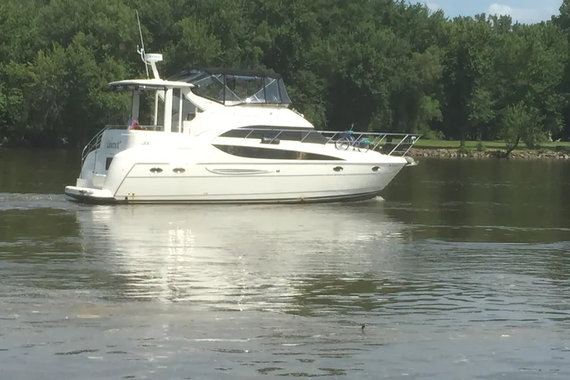 Slide: The Image of 2006 Meridian 408 Motoryacht cruising on a calm river with lush green trees. - 4