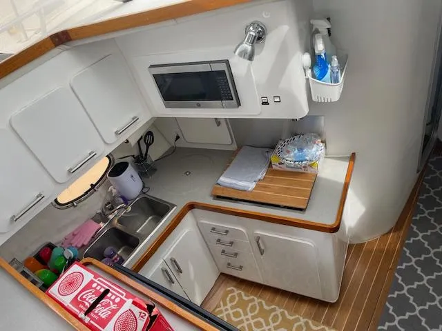 Slide: The Image of Kitchen area of a 1990 Trojan 40 Sport Fisherman boat with modern amenities. - 4