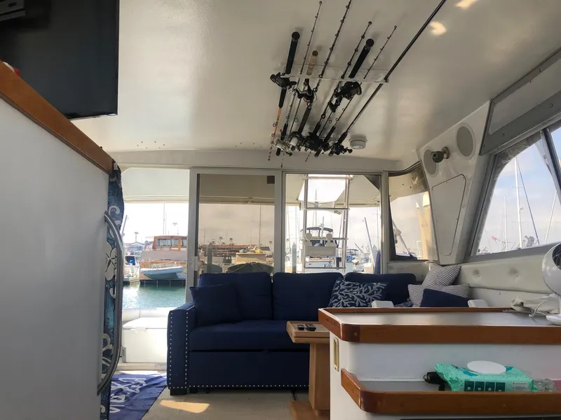 Slide: The Image of Interior of 1990 Trojan 40 Sport Fisherman boat with fishing rods and marina view. - 6