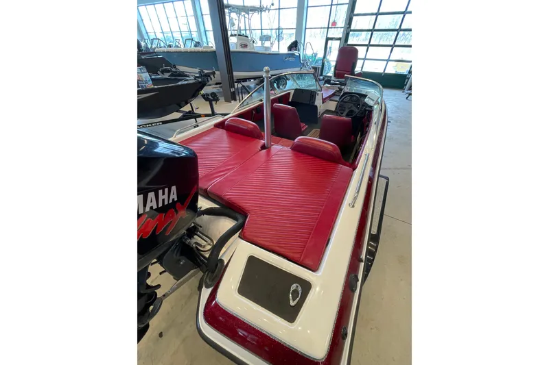 Slide: The Image of 2000 Skeeter SL 200 boat with red interior and Yamaha engine in showroom. - 2