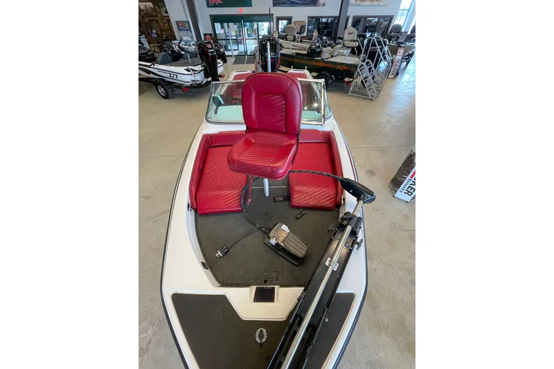 Slide: The Image of 2000 Skeeter SL 200 boat with red seating and trolling motor in showroom. - 3