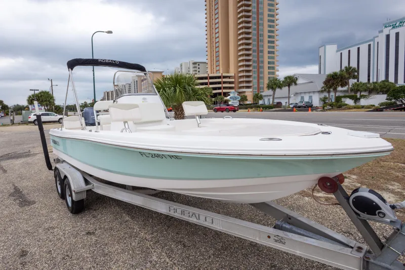 Slide: The Image of 2017 Robalo 206 Cayman boat on trailer, parked near urban buildings. - 16