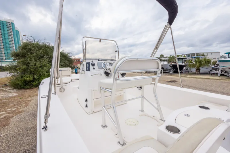 Slide: The Image of 2017 Robalo 206 Cayman boat interior with steering console and seating, parked outdoors. - 21