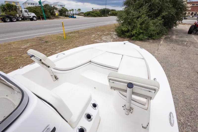 Slide: The Image of 2017 Robalo 206 Cayman boat with white seating, parked near a road and greenery. - 25