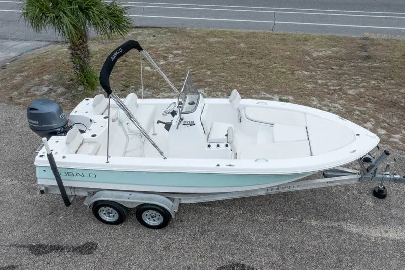 Slide: The Image of 2017 Robalo 206 Cayman boat on trailer, parked near a road and palm tree. - 3