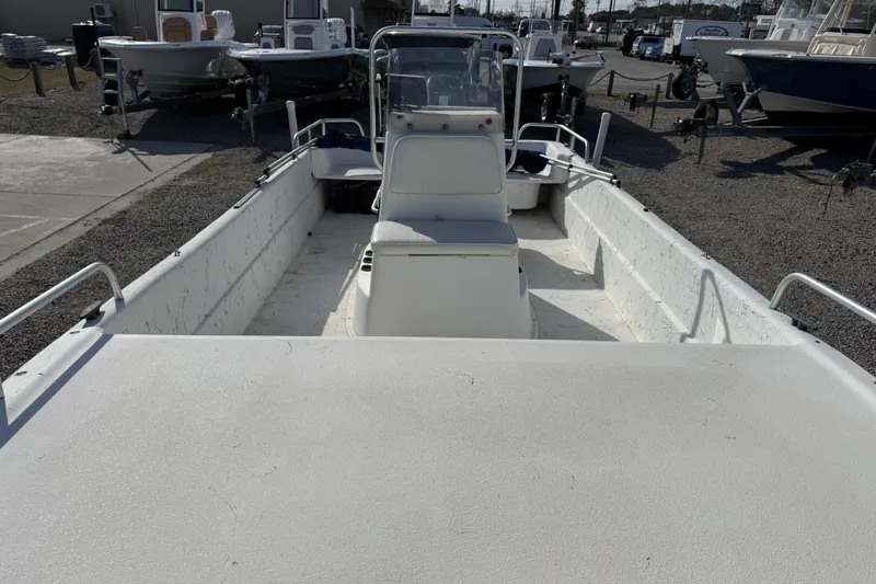 Slide: The Image of 2006 Carolina Skiff 1980 DLX boat, white interior, parked at a marina. - 16