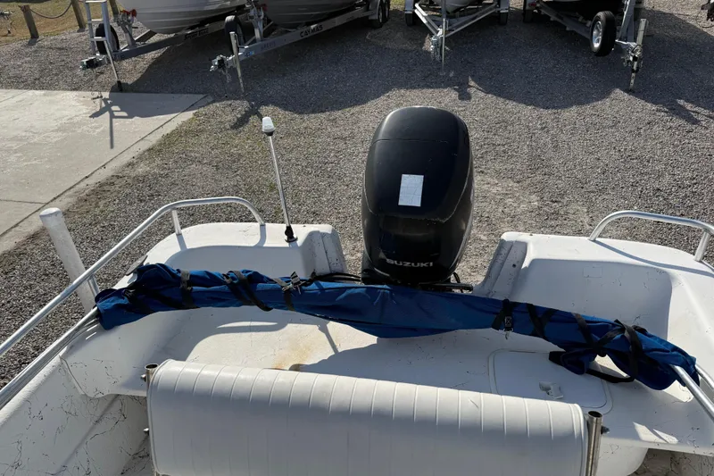 Slide: The Image of 2006 Carolina Skiff 1980 DLX boat with Suzuki outboard motor, parked on gravel. - 19