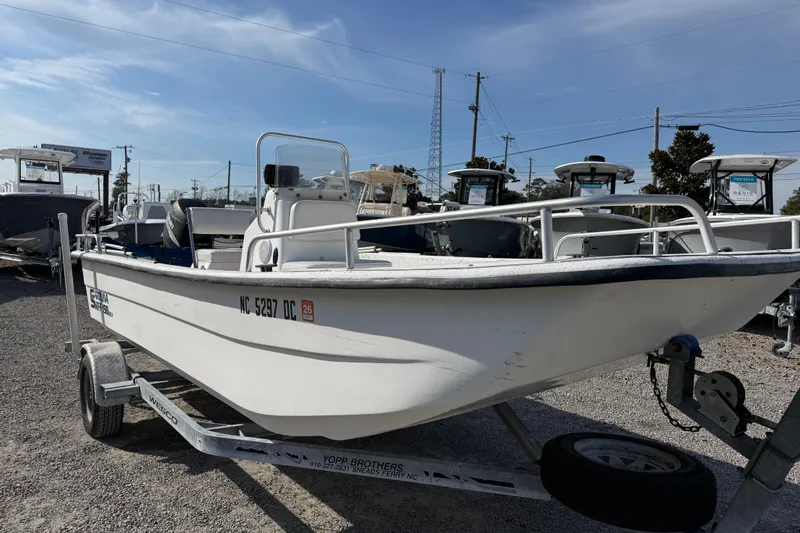 Slide: The Image of 2006 Carolina Skiff 1980 DLX boat on trailer, parked outdoors under clear sky. - 3