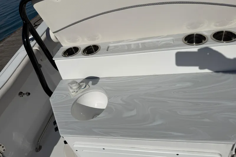 Slide: The Image of 2025 Sea Hunt Ultra 255 SE boat interior with sink and cup holders. - 16