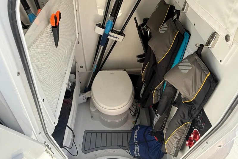 Slide: The Image of Interior of 2025 Sea Hunt Ultra 255 SE boat with life jackets and portable toilet. - 18