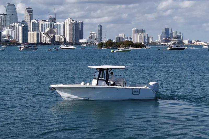 Slide: The Image of Sea Hunt Ultra 255 SE 2025 on water with city skyline. - 2