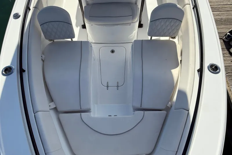 Slide: The Image of 2025 Sea Hunt Ultra 255 SE boat interior with white cushioned seating and storage compartments. - 22