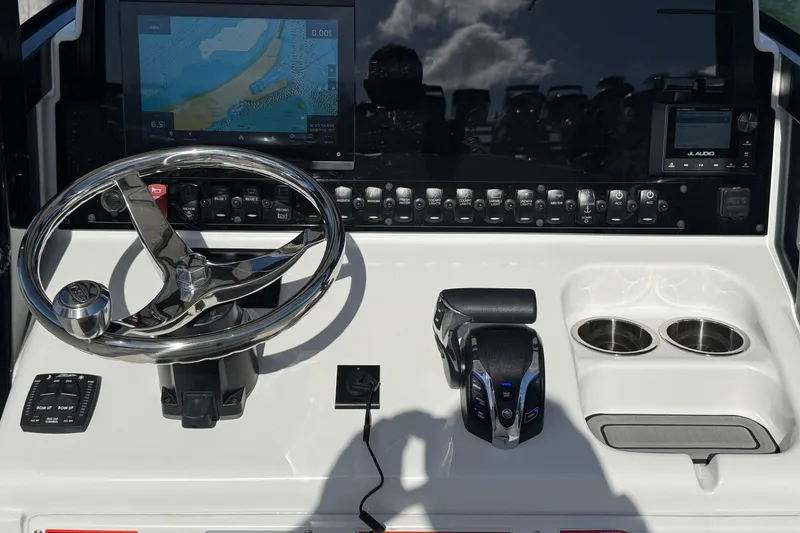 Slide: The Image of 2025 Sea Hunt Ultra 255 SE boat dashboard with steering wheel and navigation controls. - 26