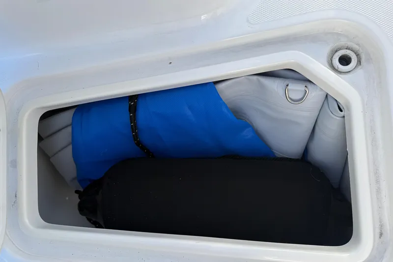 Slide: The Image of Storage compartment of 2025 Sea Hunt Ultra 255 SE boat with blue and black gear. - 29