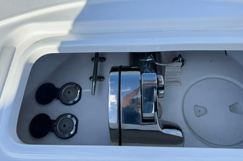 Slide: The Image of Anchor compartment of 2025 Sea Hunt Ultra 255 SE boat, featuring chrome hardware. - 33