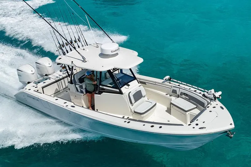 The Image of Manufacturer Provided Image: 2026 Cobia 305 Center Console boat cruising on clear turquoise water. - 0