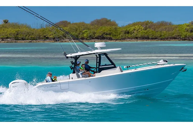 Slide: The Image of Manufacturer Provided Image: 2026 Cobia 305 Center Console boat cruising on turquoise water. - 2