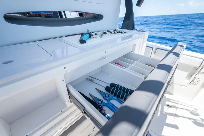 Slide: The Image of Manufacturer Provided Image: 2026 Cobia 305 Center Console boat with open storage drawers and fishing tools. - 7