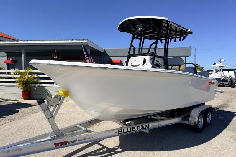Slide: The Image of 2025 Sea Pro 225FLX Sandbar boat on trailer, displayed outdoors under clear blue sky. - 2