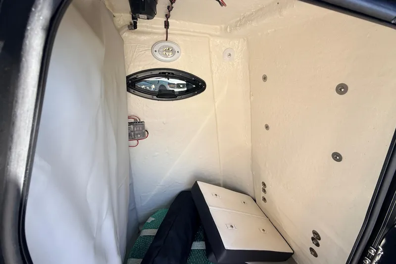 Slide: The Image of Interior cabin of 2025 Sea Pro 225FLX Sandbar boat, featuring seating and porthole. - 35