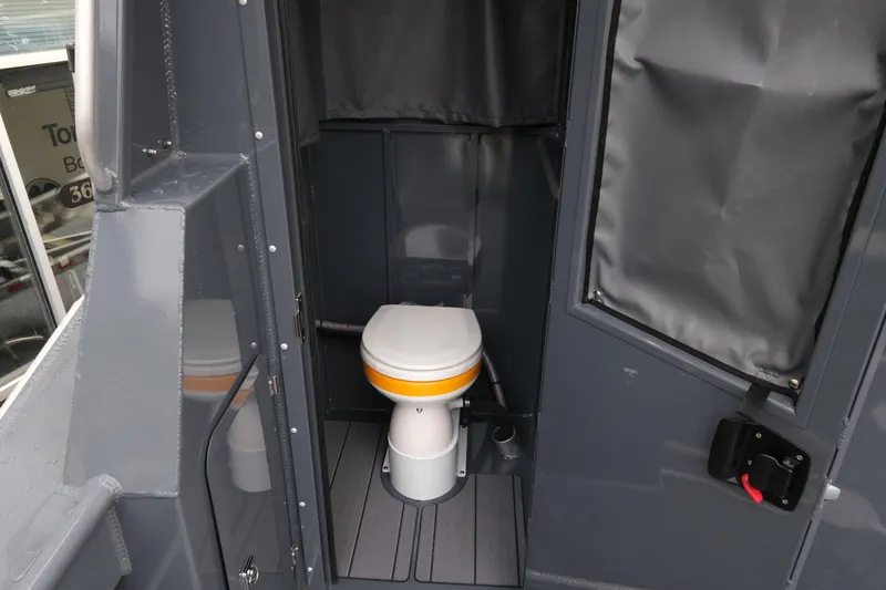 Slide: The Image of Interior of 2026 Hewescraft 270 Alaskan ET Hardtop, featuring a compact marine toilet. - 15