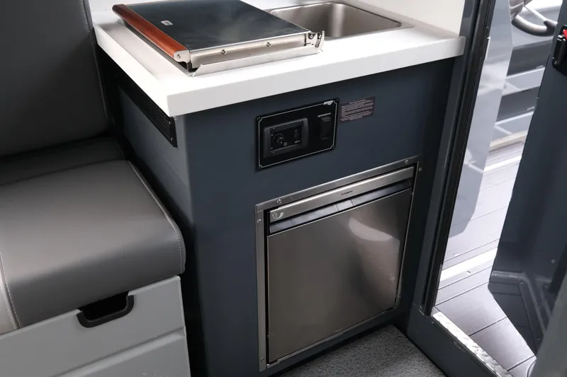 Slide: The Image of 2026 Hewescraft 270 Alaskan ET Hardtop interior with compact kitchenette and seating. - 16