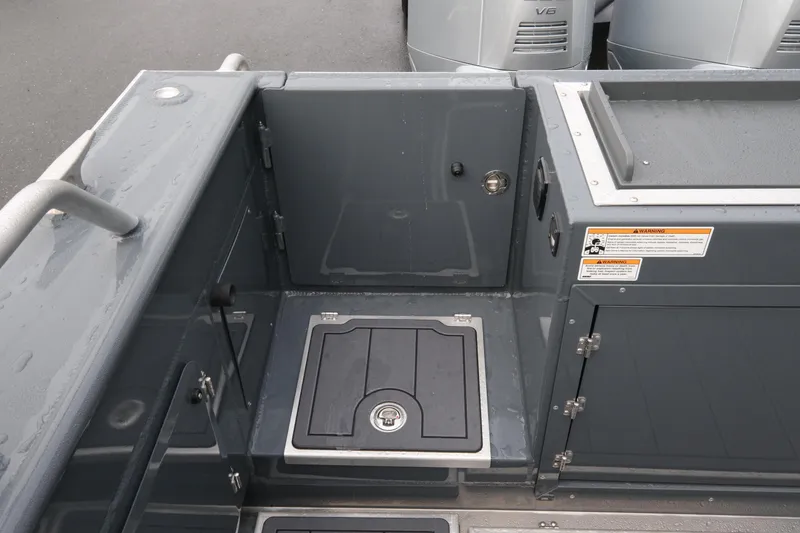 Slide: The Image of 2026 Hewescraft 270 Alaskan ET Hardtop boat deck with storage compartments and safety warnings. - 19