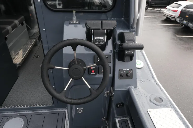 Slide: The Image of Steering console of 2026 Hewescraft 270 Alaskan ET Hardtop boat in a parking lot. - 7