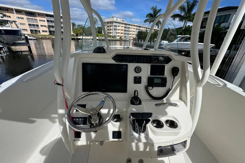 Slide: The Image of 2016 Sailfish 320 CC boat dashboard with steering wheel and navigation controls. - 10