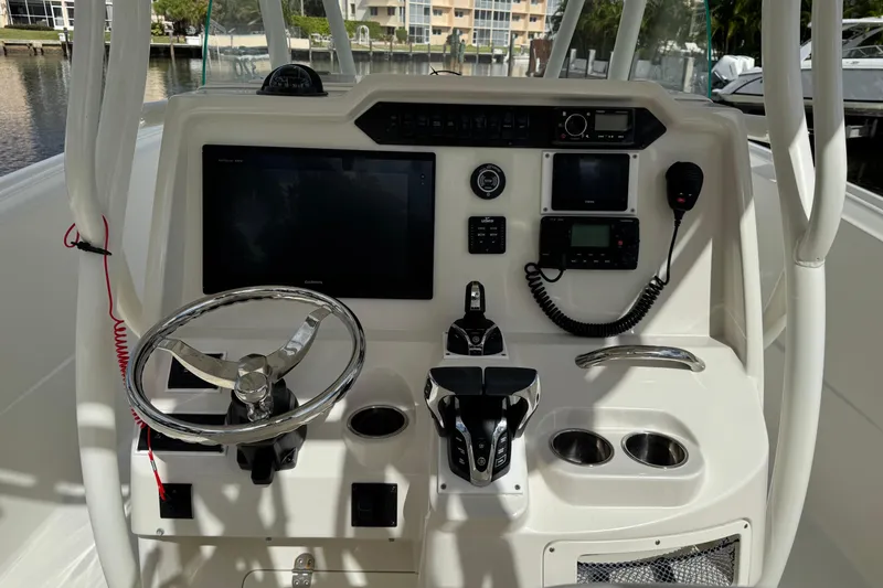 Slide: The Image of Control panel of a 2016 Sailfish 320 CC boat with steering wheel and navigation equipment. - 11