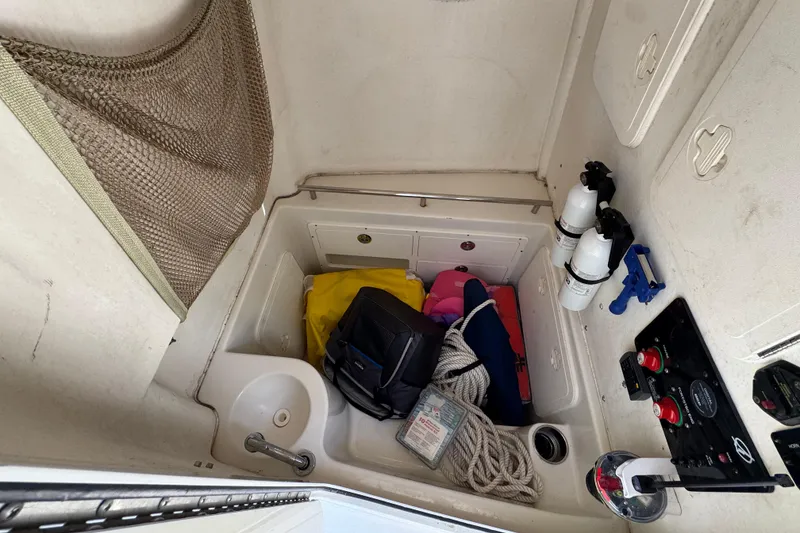 Slide: The Image of Interior of 2016 Sailfish 320 CC boat with storage, safety gear, and fire extinguishers. - 17