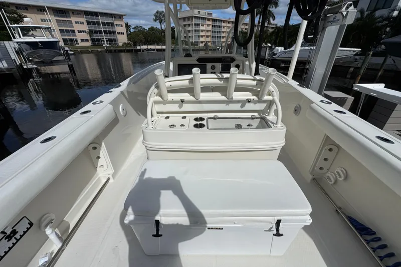Slide: The Image of 2016 Sailfish 320 CC boat interior with fishing rod holders and storage, docked at marina. - 6
