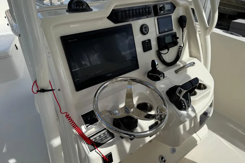 Slide: The Image of 2016 Sailfish 320 CC boat dashboard with steering wheel, navigation screens, and controls. - 8
