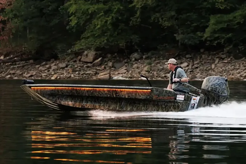 The Image of Manufacturer Provided Image: 2026 SeaArk 1752 Slayer Pro boat cruising on a calm lake with forested shoreline. - 0