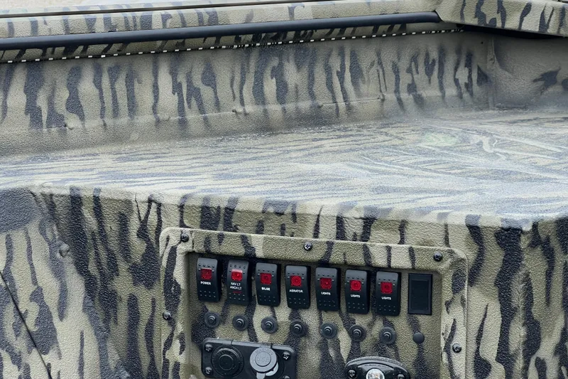 Slide: The Image of 2026 SeaArk 1752 Slayer X Pro boat with camouflage design and control panel. - 7