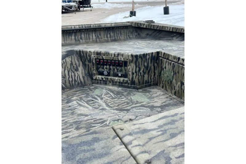 Slide: The Image of 2026 SeaArk 1752 Slayer X Pro boat interior with camouflage design and control panel. - 9